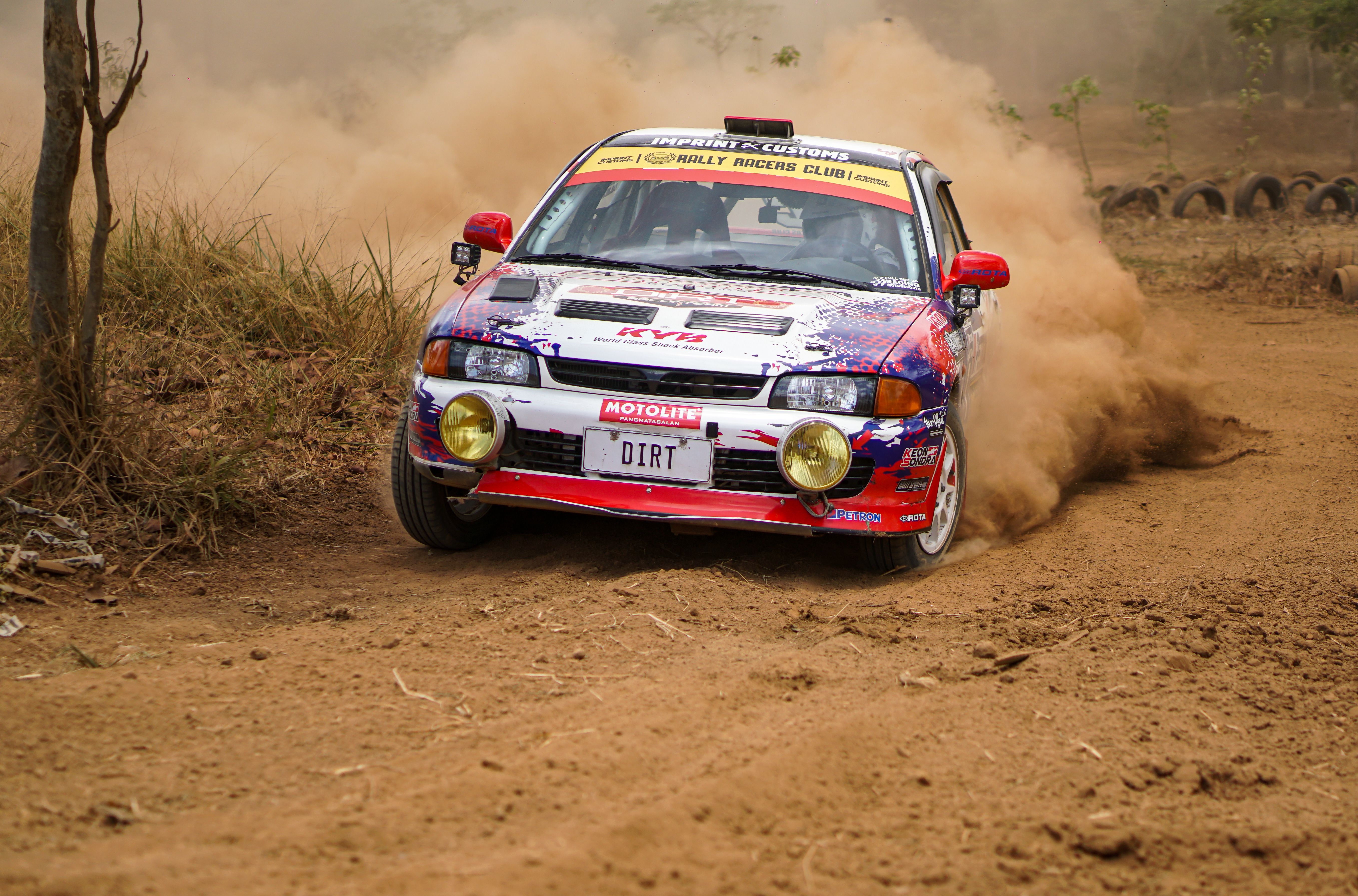 A rally car driving on dirt road · Free Stock Photo