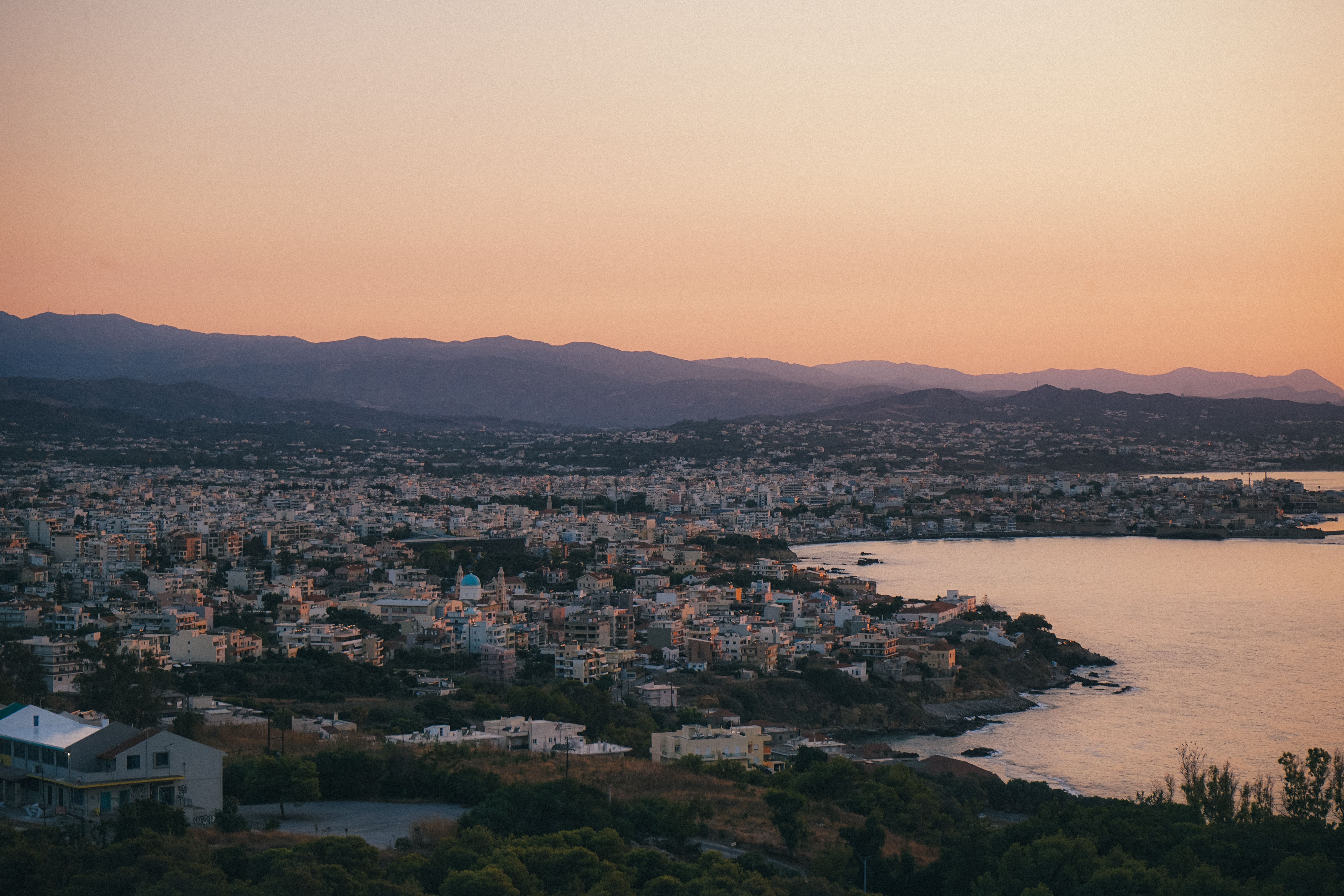 A stunning sunset view over Chania, Greece, highlighting its coastal cityscape and serene sea.
