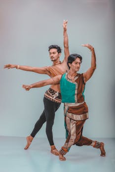 两名男舞者身着传统服装，在室内优雅地表演舞蹈