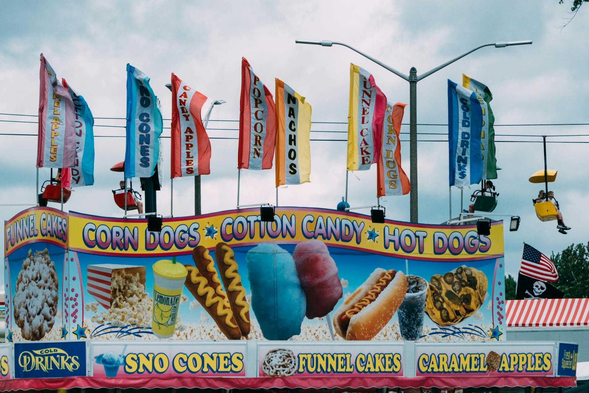 A carnival with a sign that says corn dog and hot dog