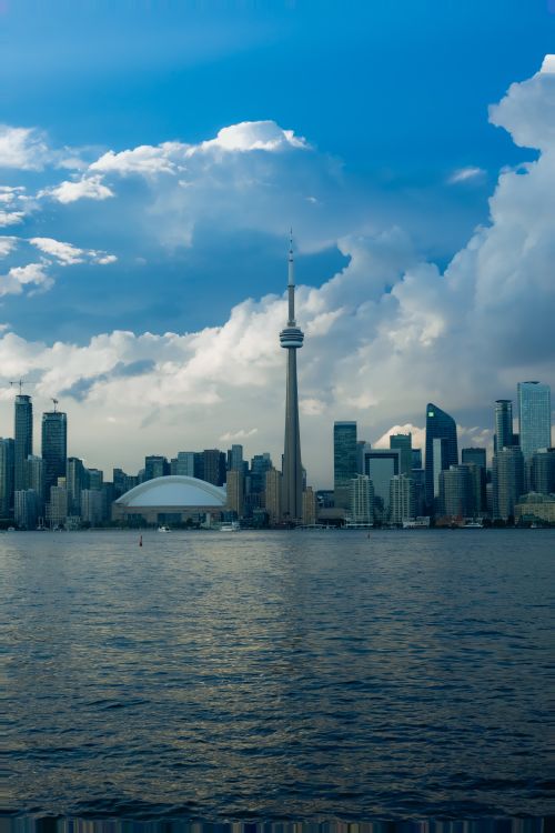 Free Captivating view of Toronto's skyline featuring the CN Tower over Lake Ontario's waters. Stock Photo