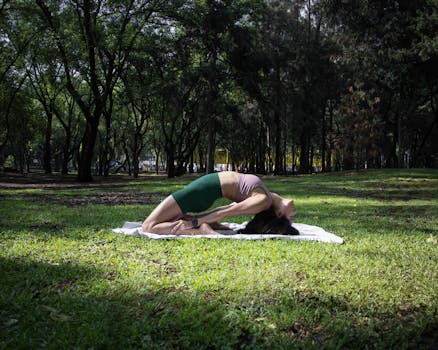 Woman performing a yoga pose on a sunny day in a lush green park in Ciudad de México.