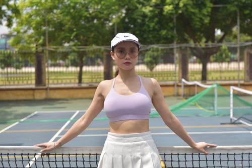 Free Confident woman standing on a tennis court, embodying fitness and style. Stock Photo