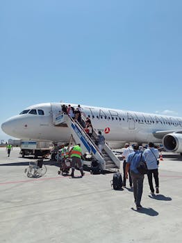 Travelers boarding a commercial aircraft at Iğdır Airport in Türkiye on a sunny day.