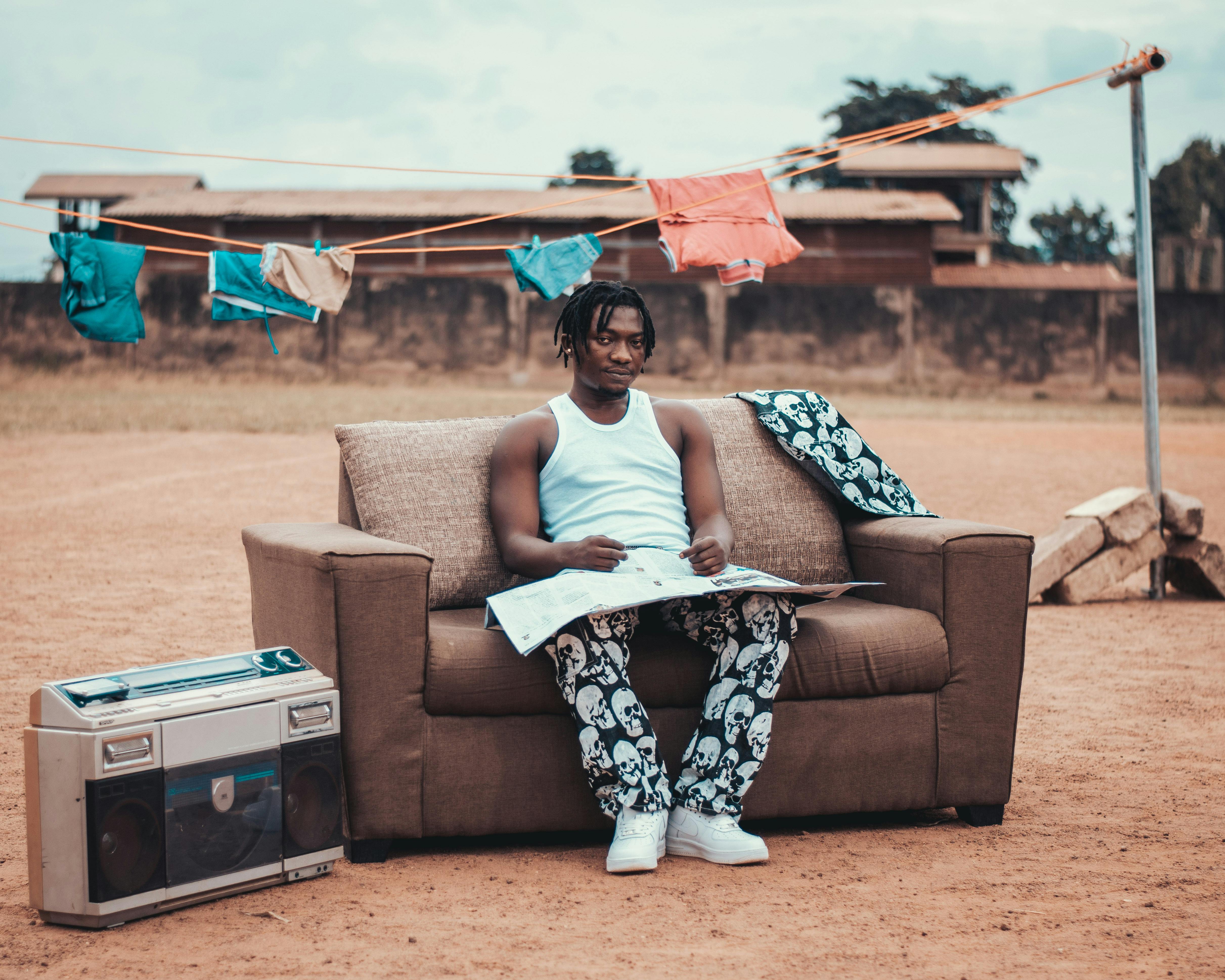 a man sitting on a couch in front of a clothes line