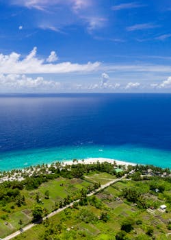 从空中俯瞰马尔代夫的海岸线，碧绿的海水、椰子树和郁郁葱葱的植被令人惊叹