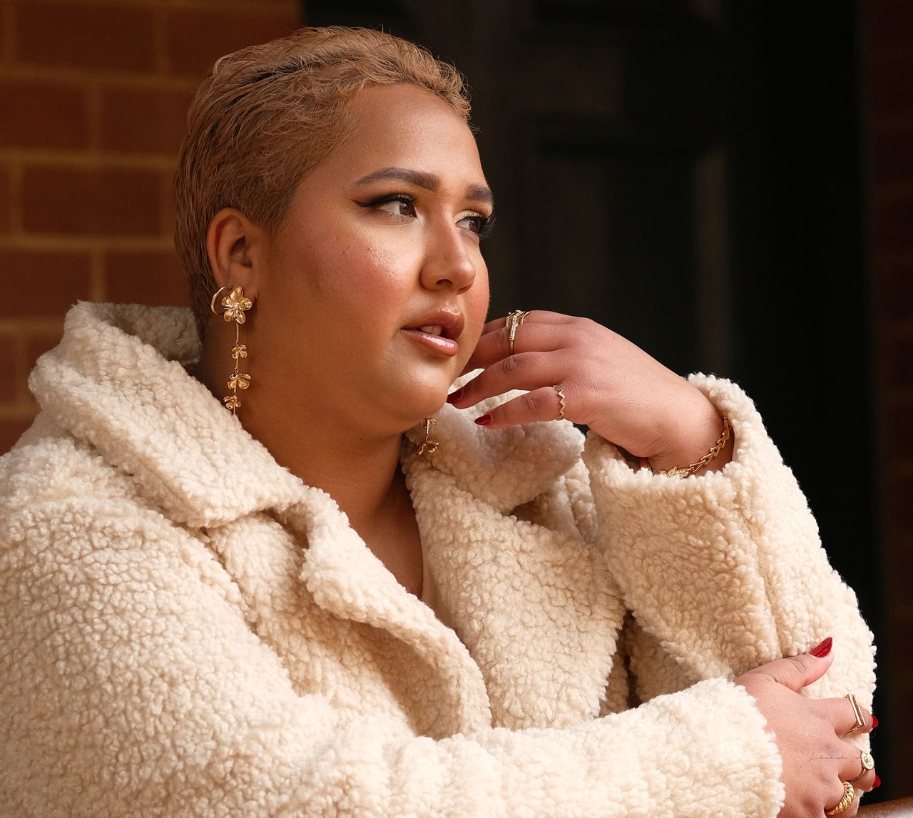 Woman in a white sherpa fleece coat with gold jewellery