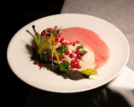 Elegant plate of chile en nogada, garnished with fresh pomegranate and herbs, showcasing Mexican cuisine.