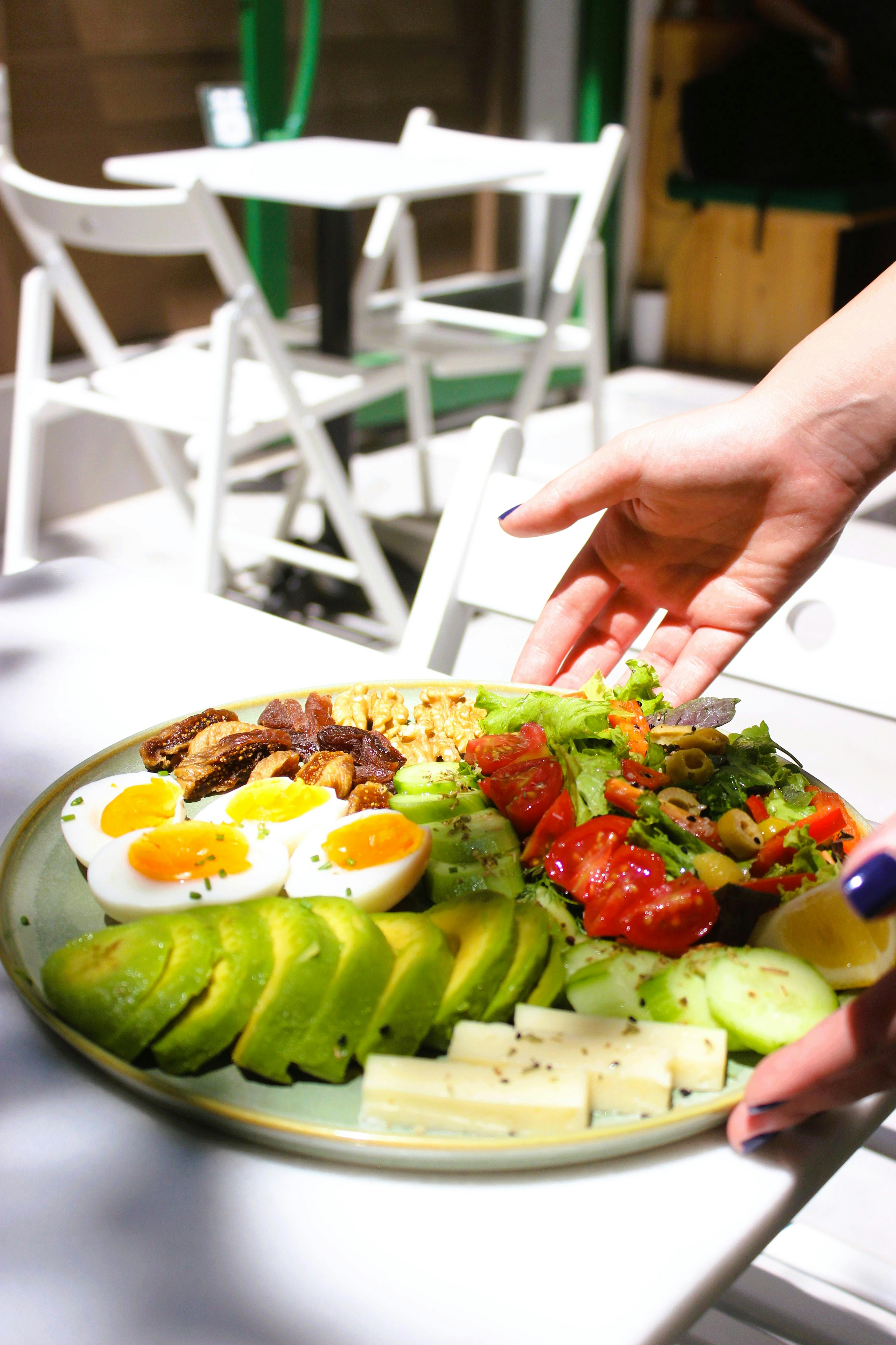 Nutrient-rich breakfast salad featuring avocado, eggs, and fresh vegetables on a sunny patio.