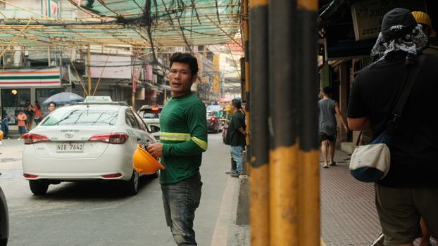 Dynamic street scene in Manila, showcasing workers and vibrant urban life.
