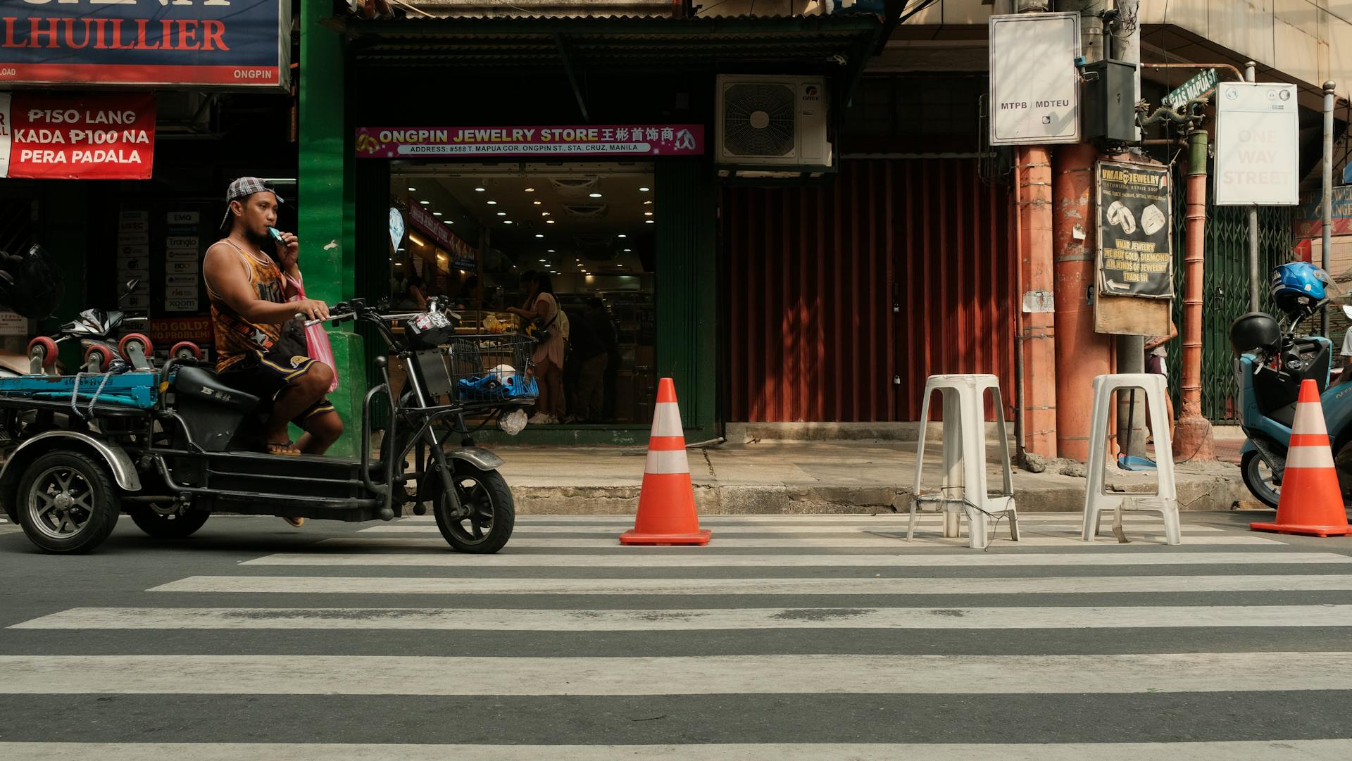 Captured at a bustling Manila street, showcasing a local vendor on a tricycle amidst urban life.