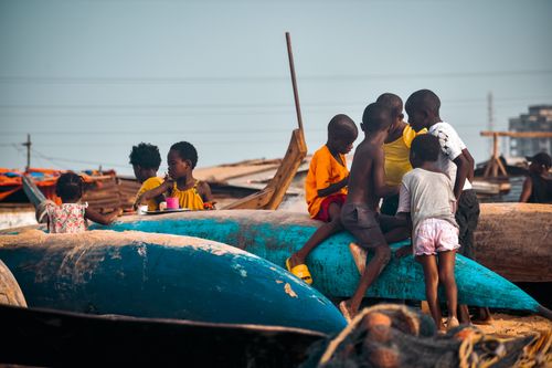 Free A group of African children playing on colorful fishing boats by the Monrovia coastline. Stock Photo