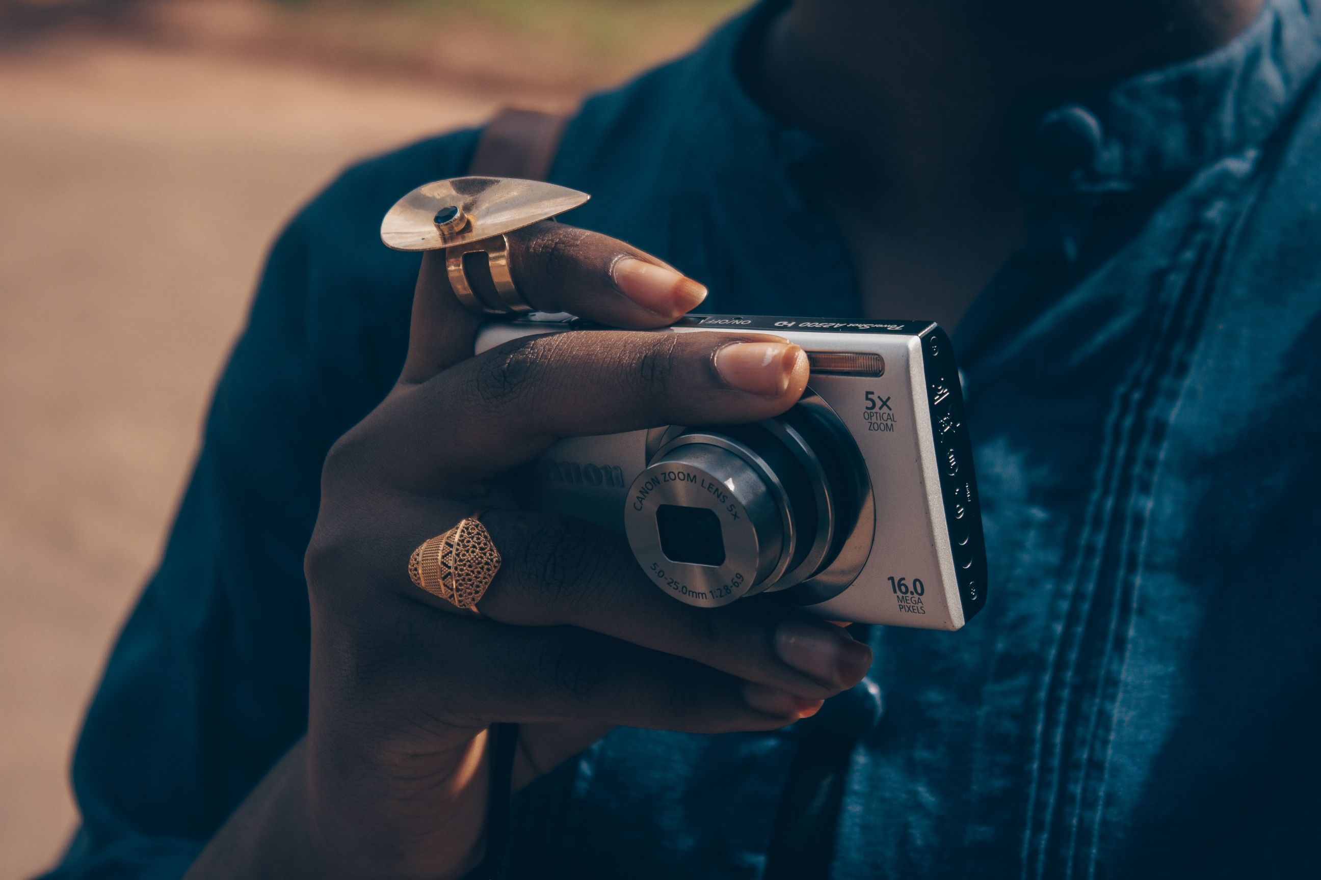 A person holding a camera with a ring on their finger · Free Stock Photo
