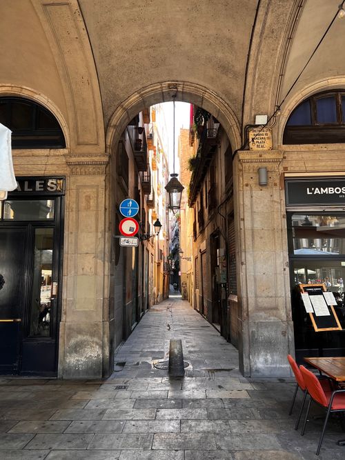 Free Explore the narrow streets and historic architecture of Barcelona's Gothic Quarter through this beautiful archway. Stock Photo