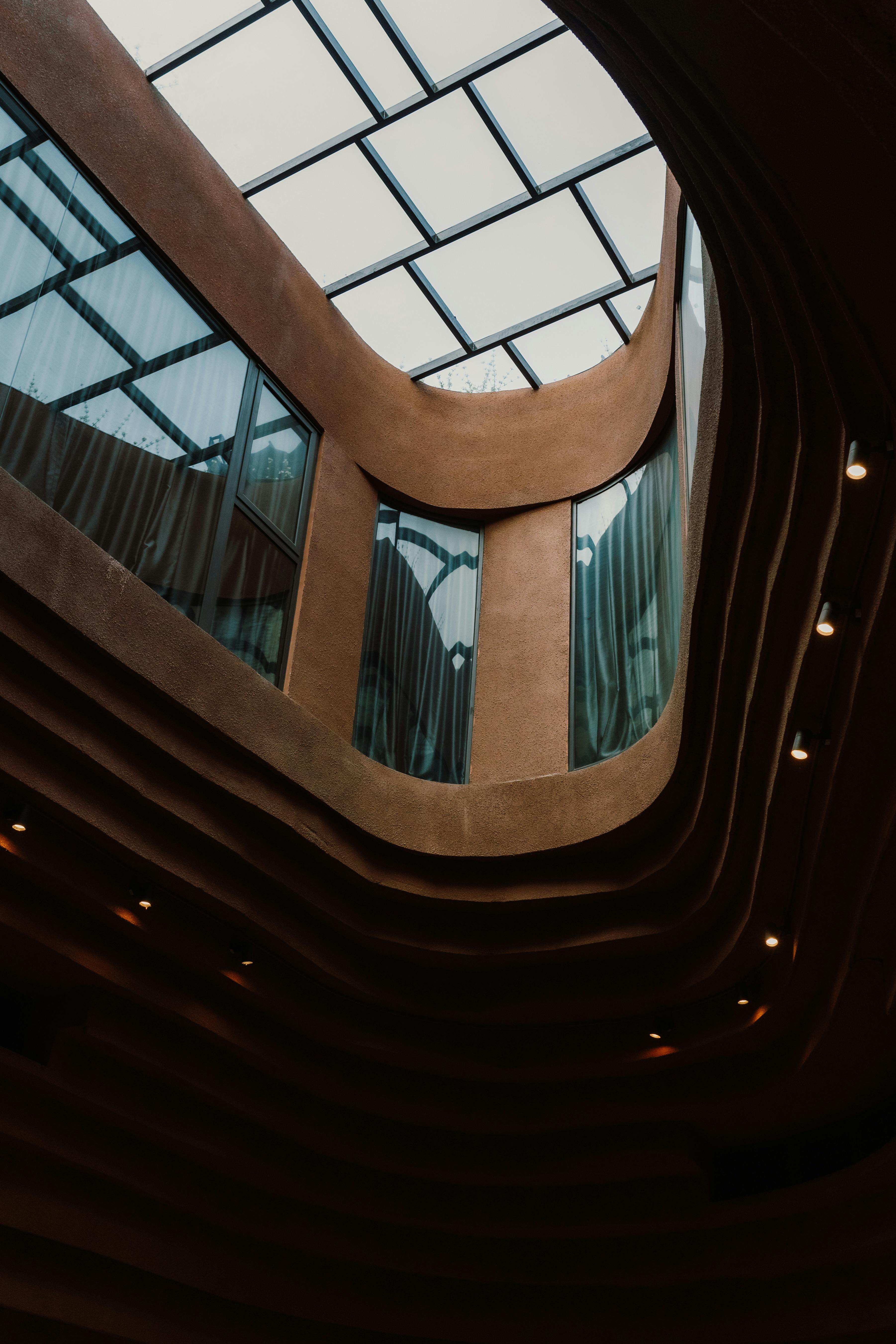 Architectural interior view of a modern curved building structure with a glass skylight.