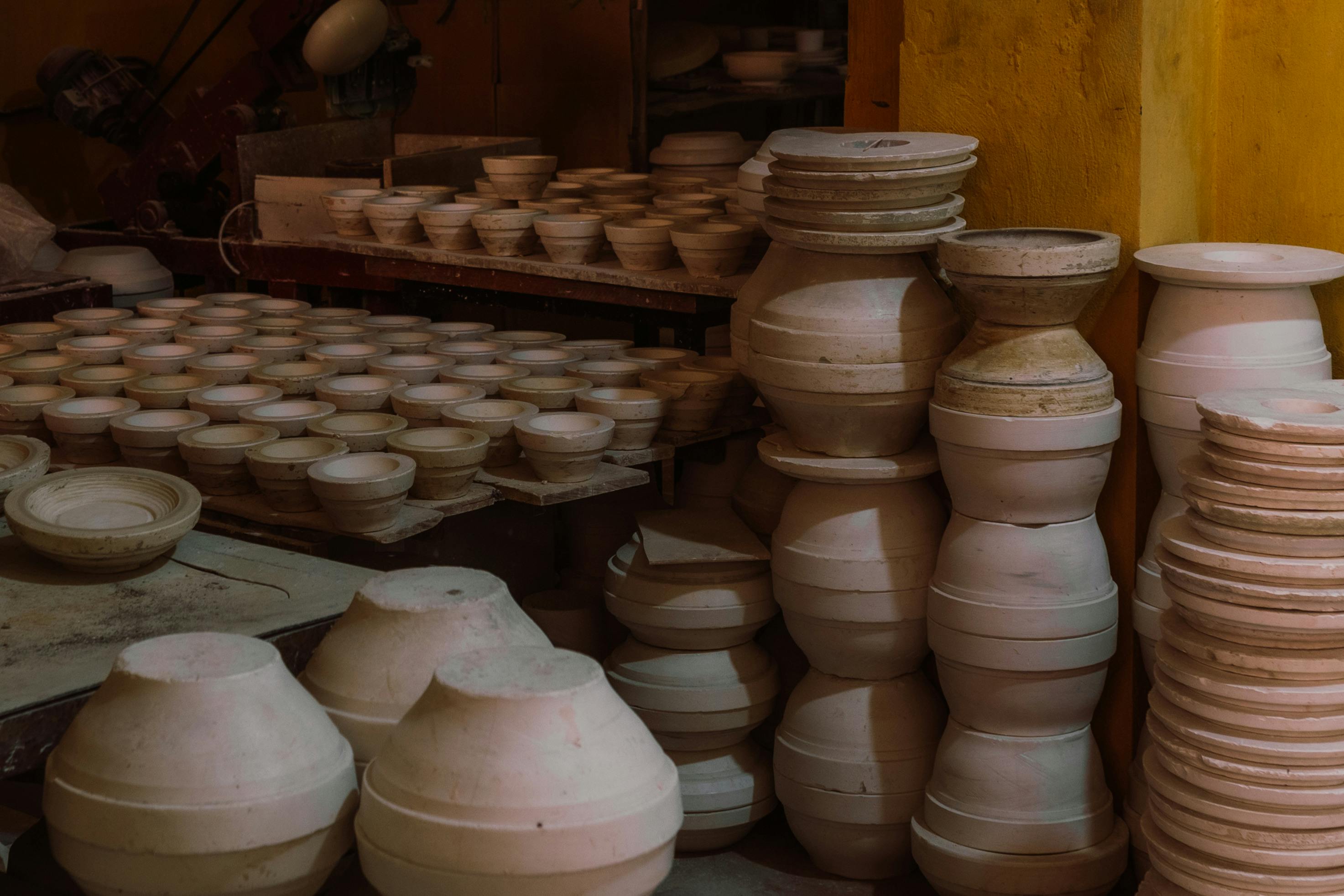 A collection of handcrafted pottery jugs and bowls in a traditional artisan workshop.
