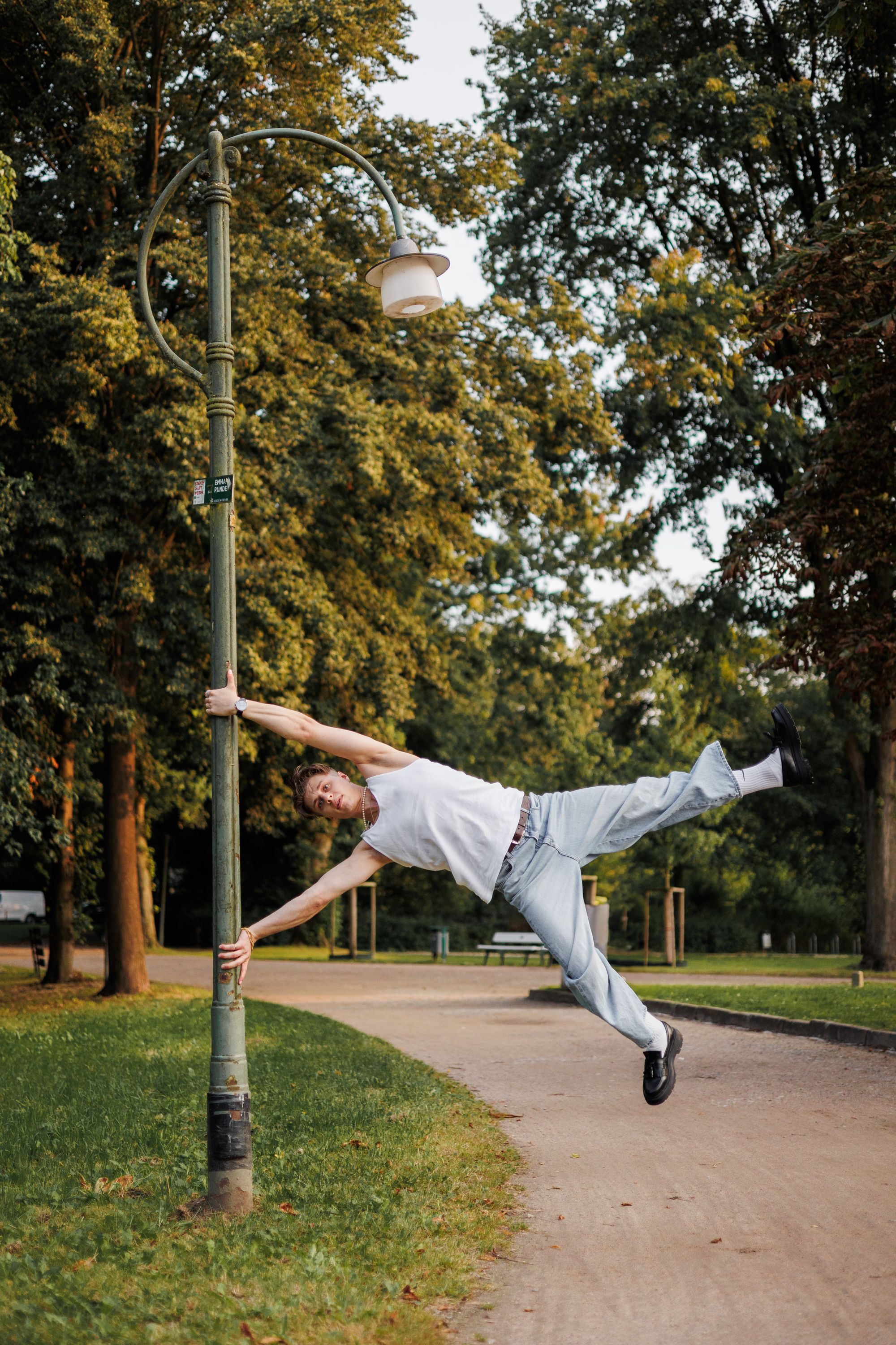 A man doing a handstand on a lamp post · Free Stock Photo