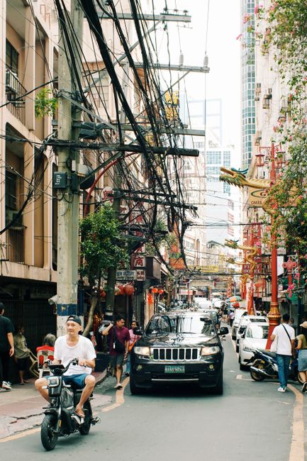 Dynamic cityscape showing traffic and people on a busy street with urban architecture.