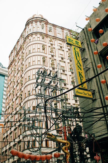 Iconic city street view with historic building and vibrant Chinese signage, perfect for tourism and urban themes.