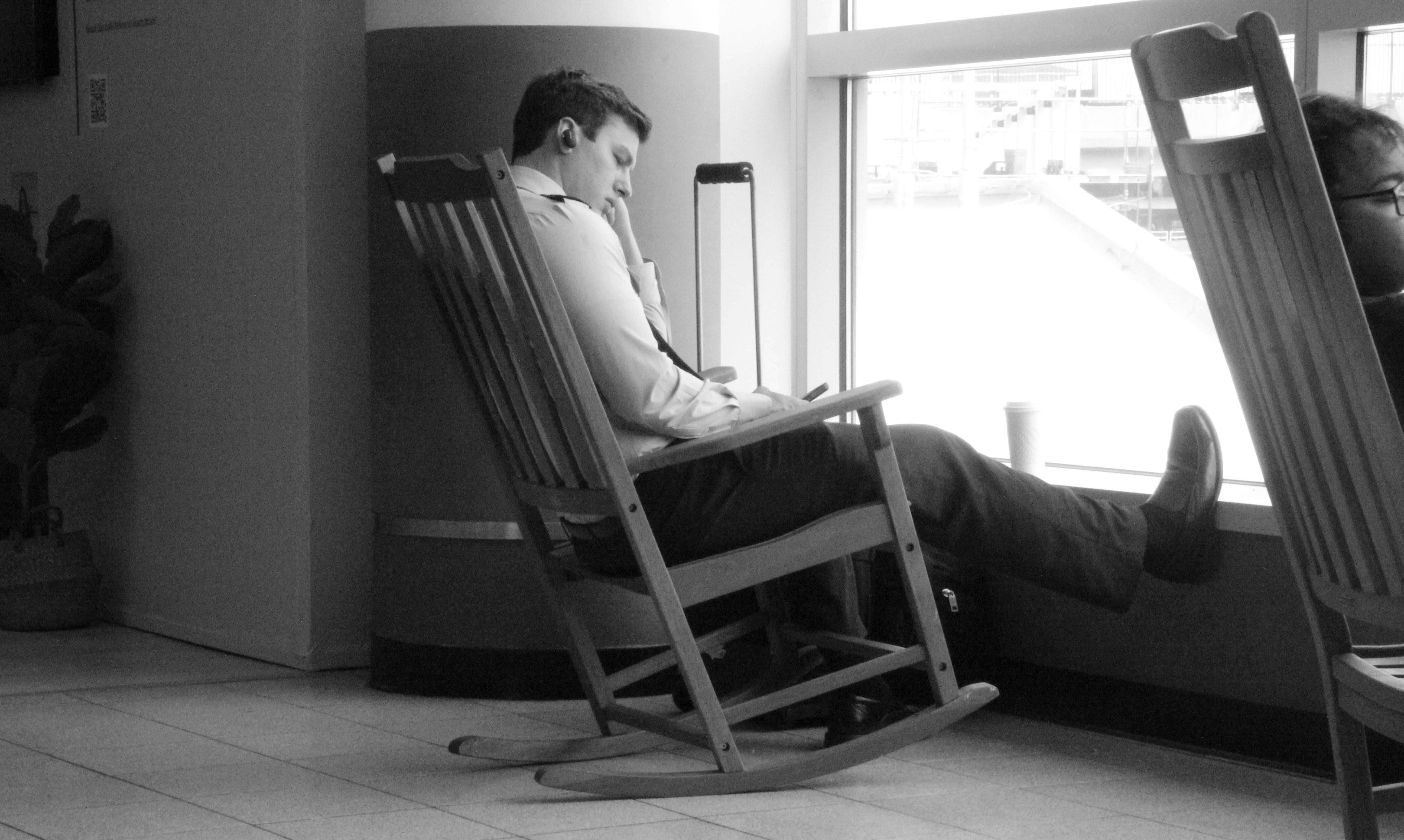 a man sitting in a rocking chair by a window