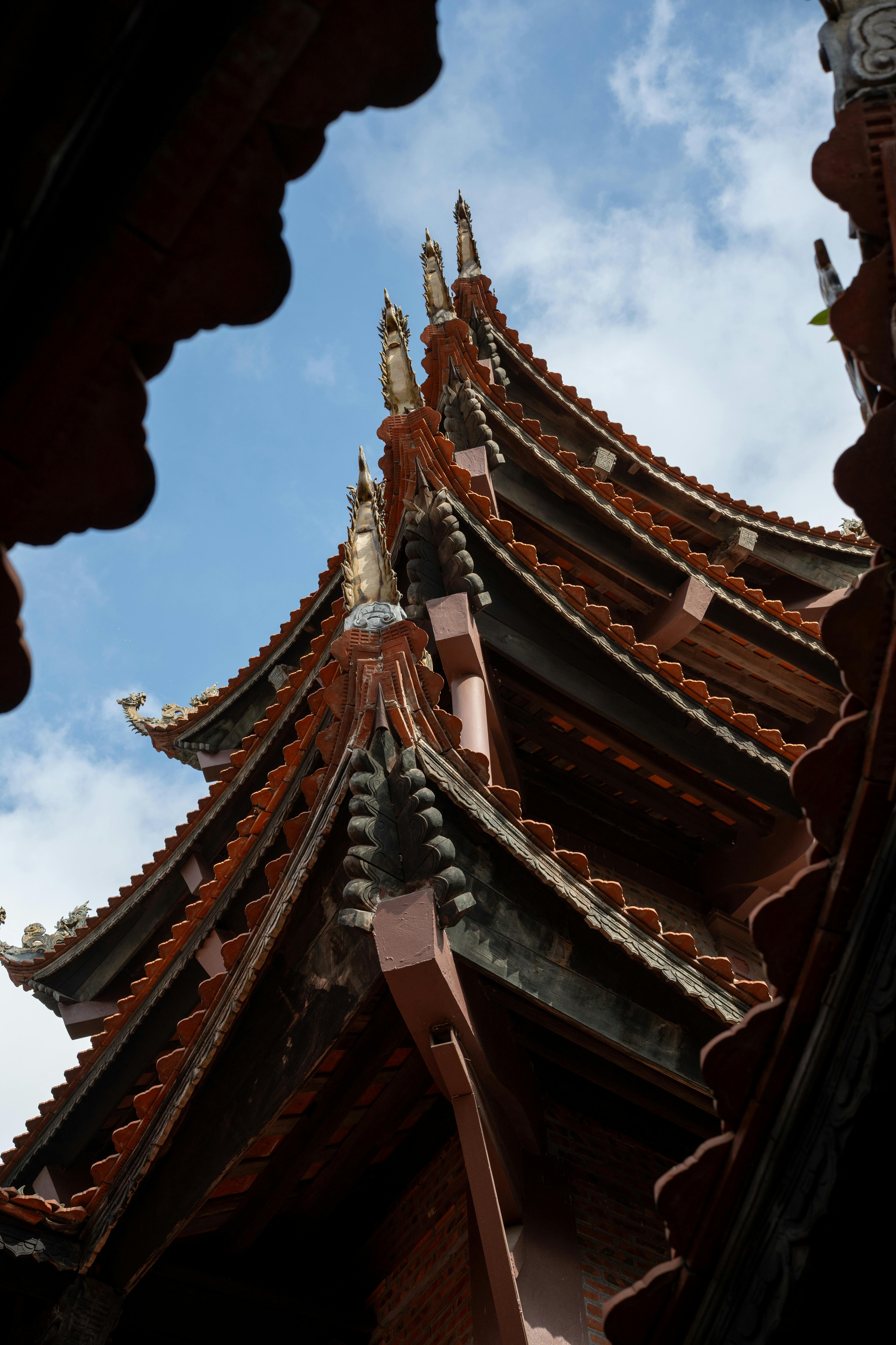 Stunning view of a traditional pagoda roof with intricate details set against a clear blue sky.