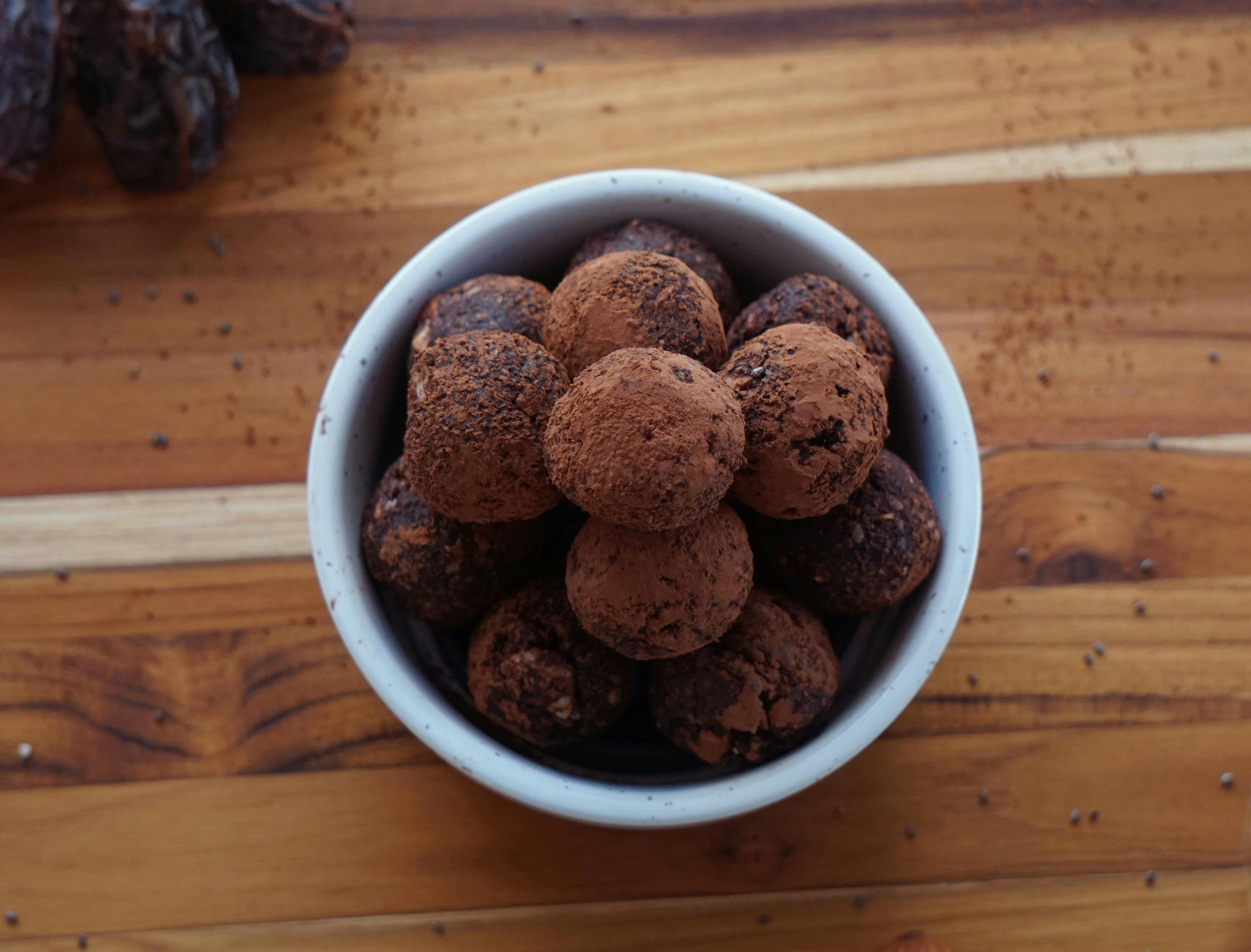 chocolate truffles in a bowl on a wooden table