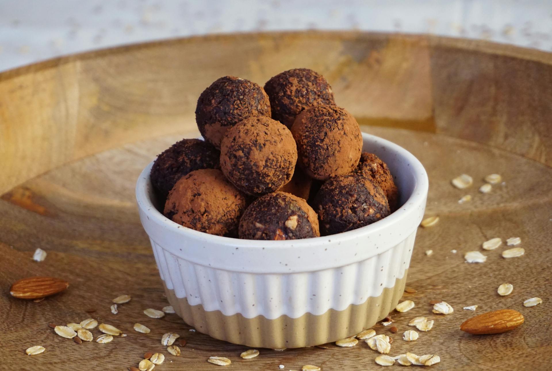 A bowl of chocolate balls with oats on top