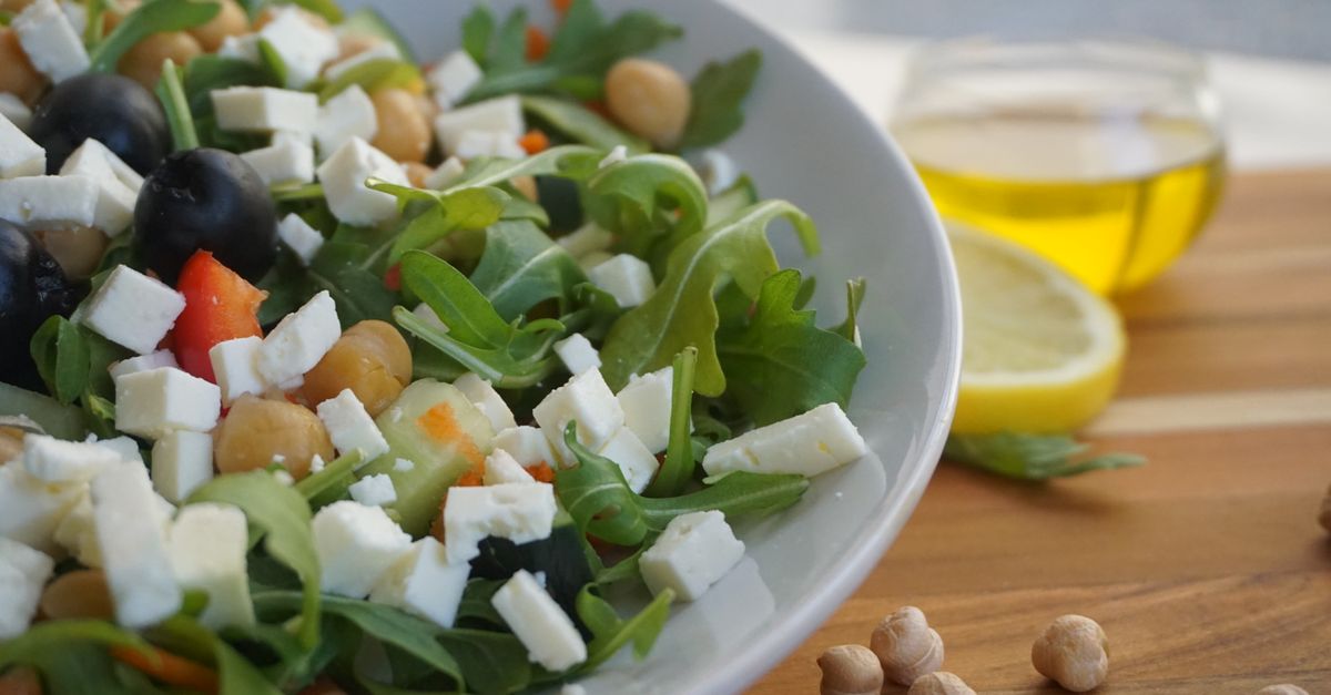 A colorful Mediterranean salad featuring feta, olives, chickpeas, and fresh greens.
