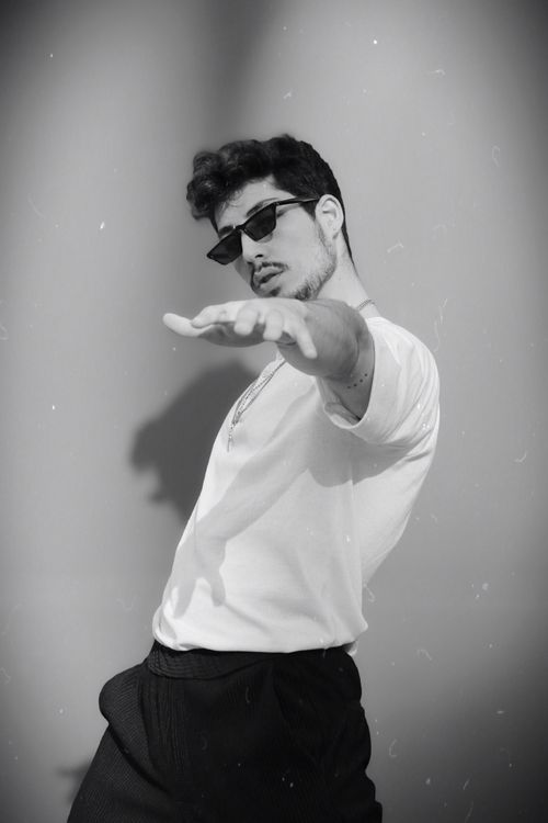 Free Black and white portrait of a confident man with sunglasses posing indoors. Stock Photo