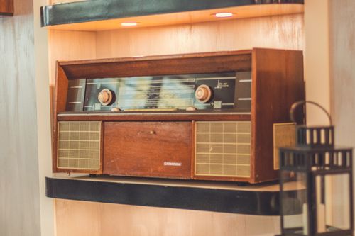 Free A nostalgic wooden radio displayed on a shelf, showcasing retro design in a classic home interior. Stock Photo