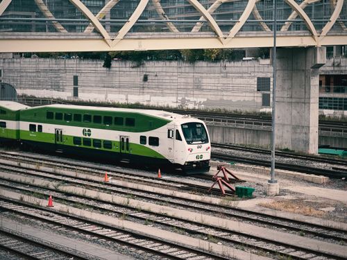Free A Go Transit train traveling on urban railway tracks under a bridge. Stock Photo