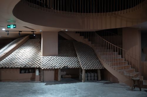 Free Contemporary interior featuring stairs and unique rustic roofing design in a dimly lit space. Stock Photo