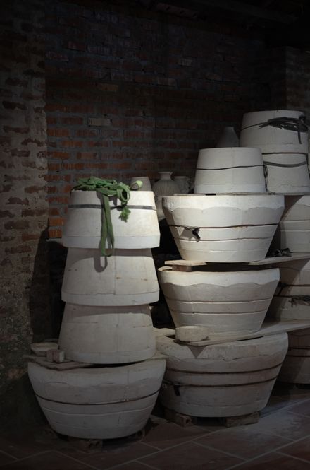 Stacks of pale clay pots on rustic shelving — photo by Lucas Tran on Pexels