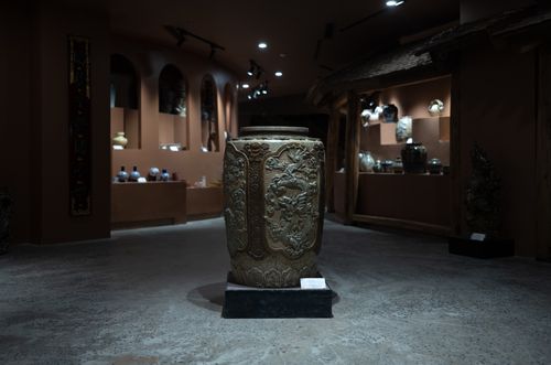 Free Intricately carved stone vase in a dimly lit museum interior showcasing ancient artifacts. Stock Photo