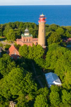 Scenic aerial shot of Cape Arkona lighthouse in summer surrounded by lush greenery.