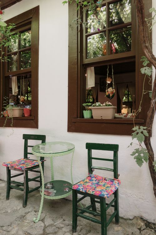 Free A quaint outdoor seating area featuring floral cushion chairs and vintage decor. Stock Photo