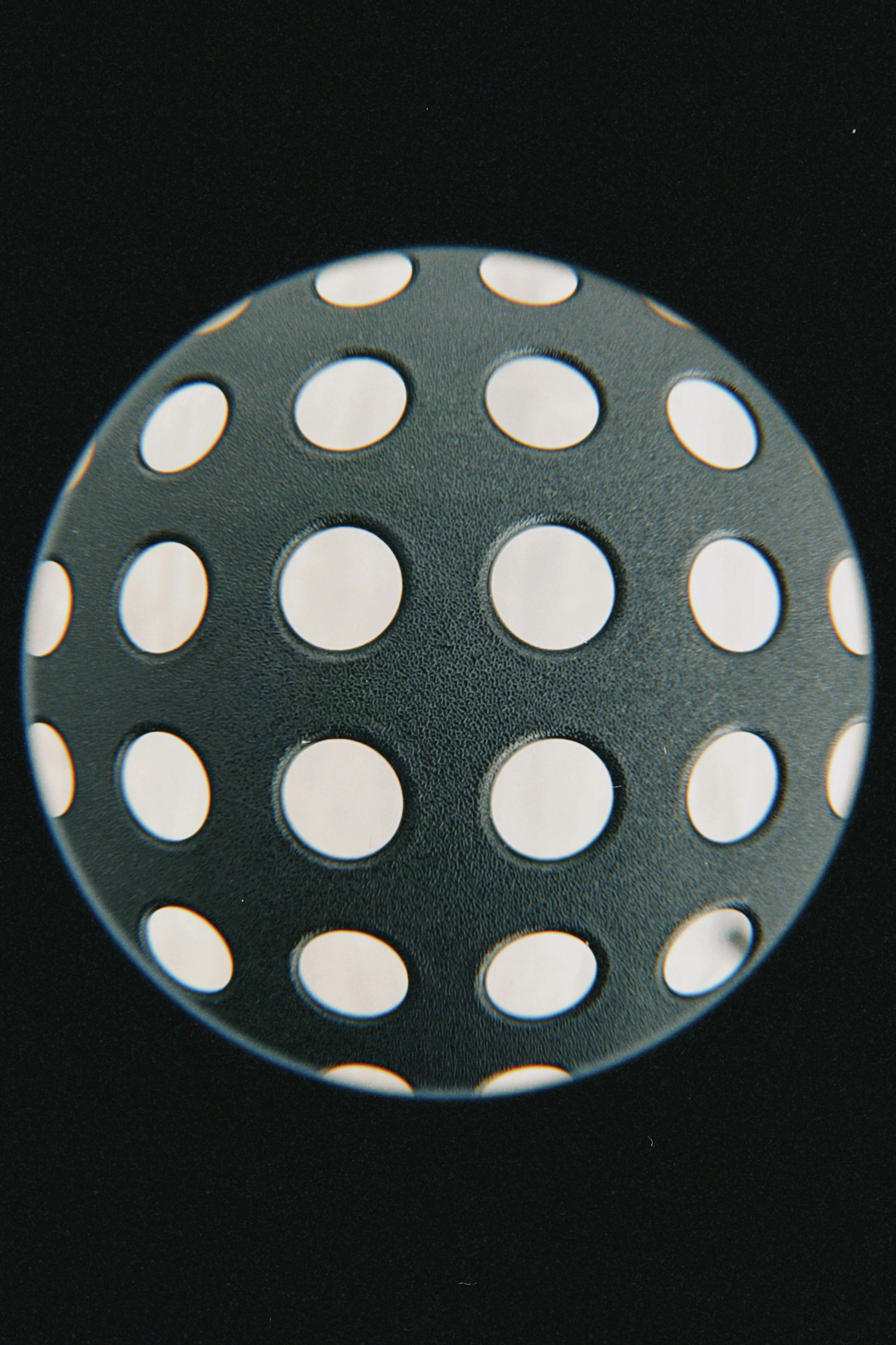 A creative fisheye perspective of a perforated sphere with circular holes.
