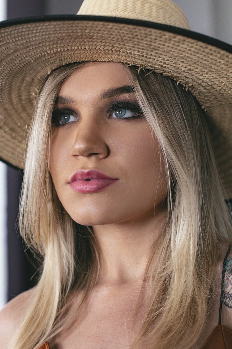 Close-Up Photo Of Woman Wearing Wicker Hat