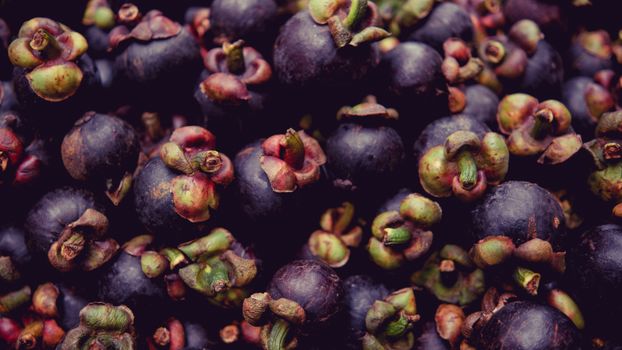 A vibrant display of ripe mangosteen fruits at a market in Manila, Philippines.