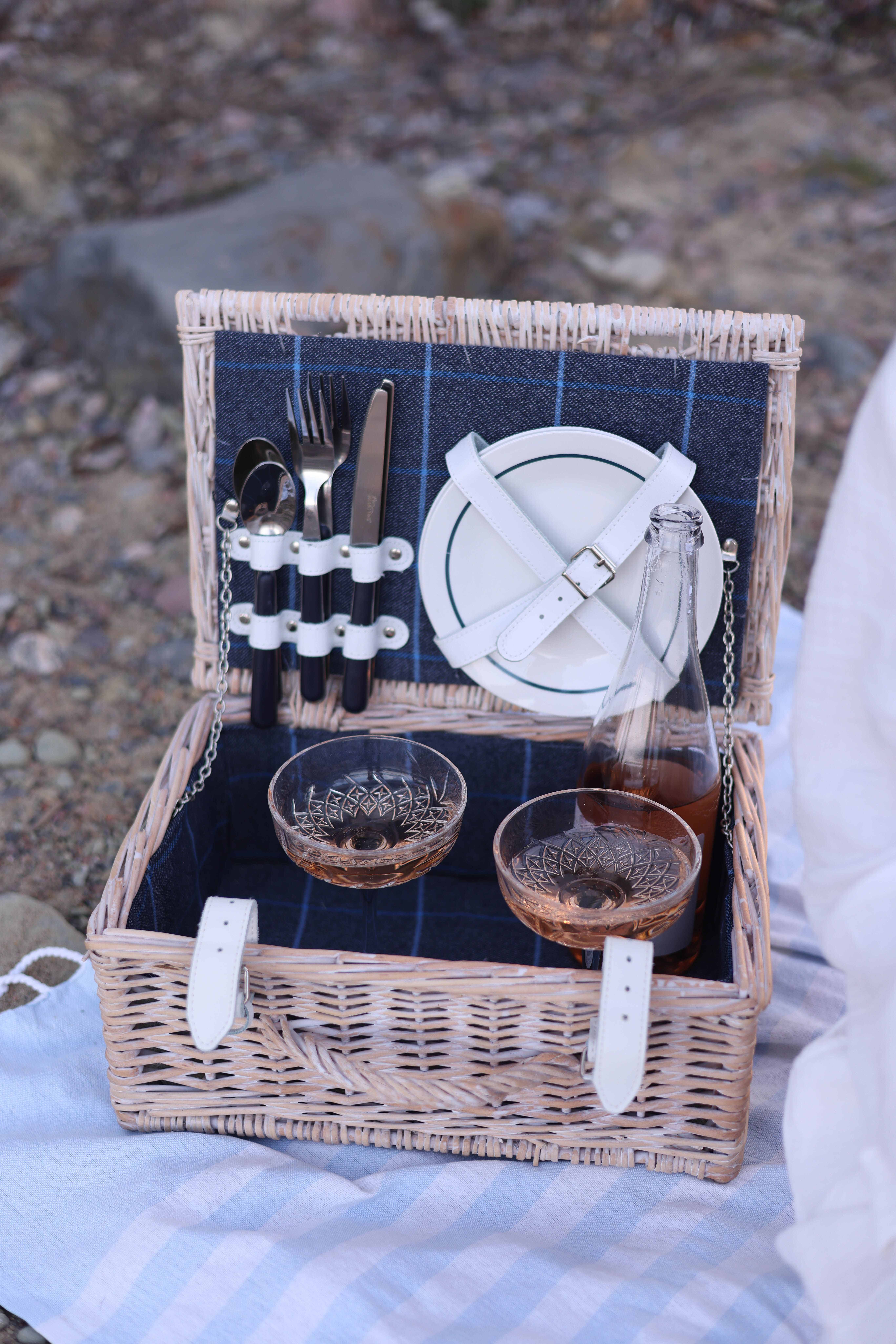 A picnic basket with wine glasses and plates · Free Stock Photo