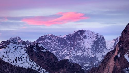 Free Snow-covered Dolomite peaks with pink skies during sunset create a serene landscape. Stock Photo