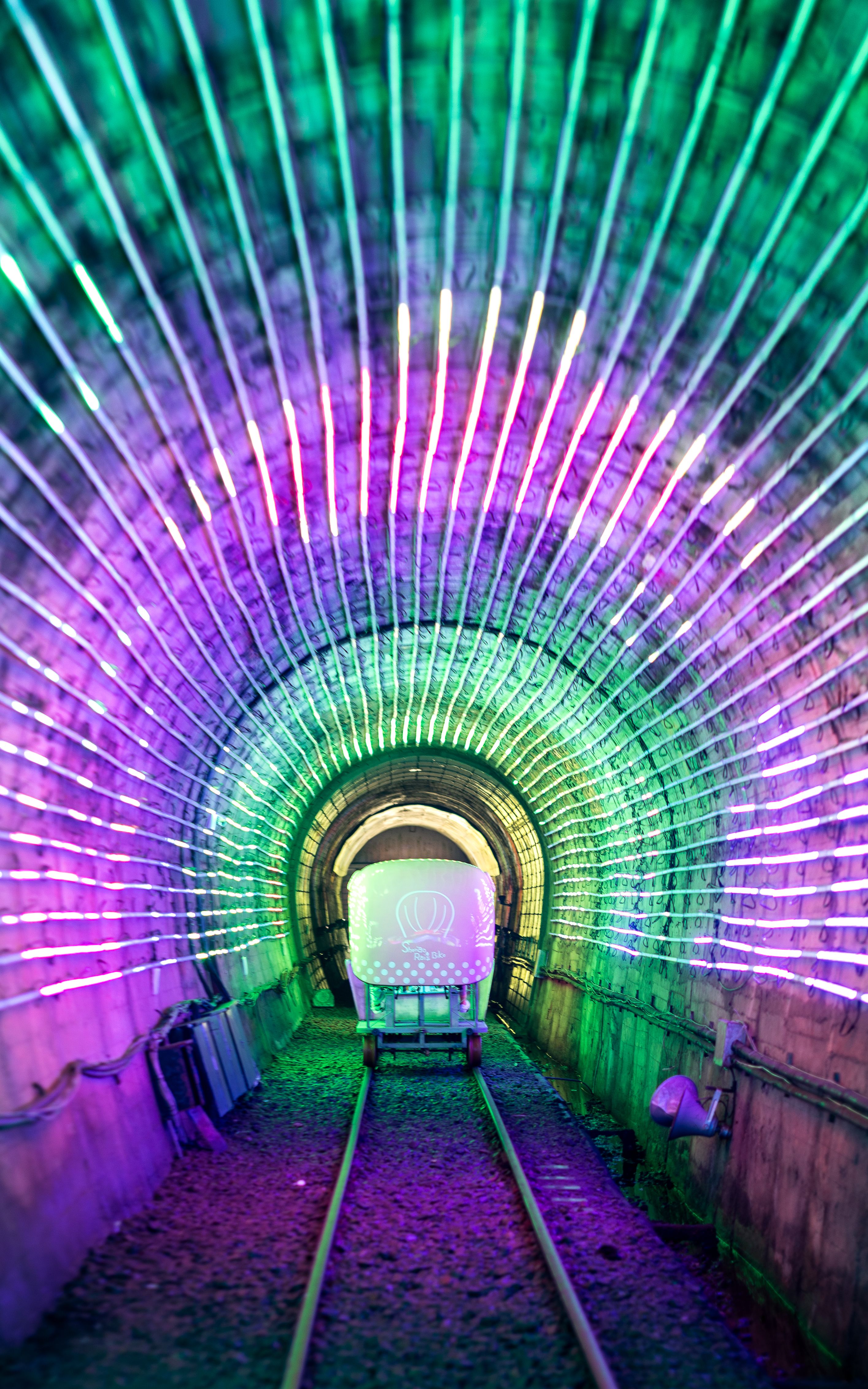 A tunnel with lights and a train going through it · Free Stock Photo