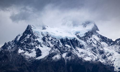 Free Breathtaking view of Torres del Paine's majestic, snow-covered mountains under cloudy skies. Stock Photo