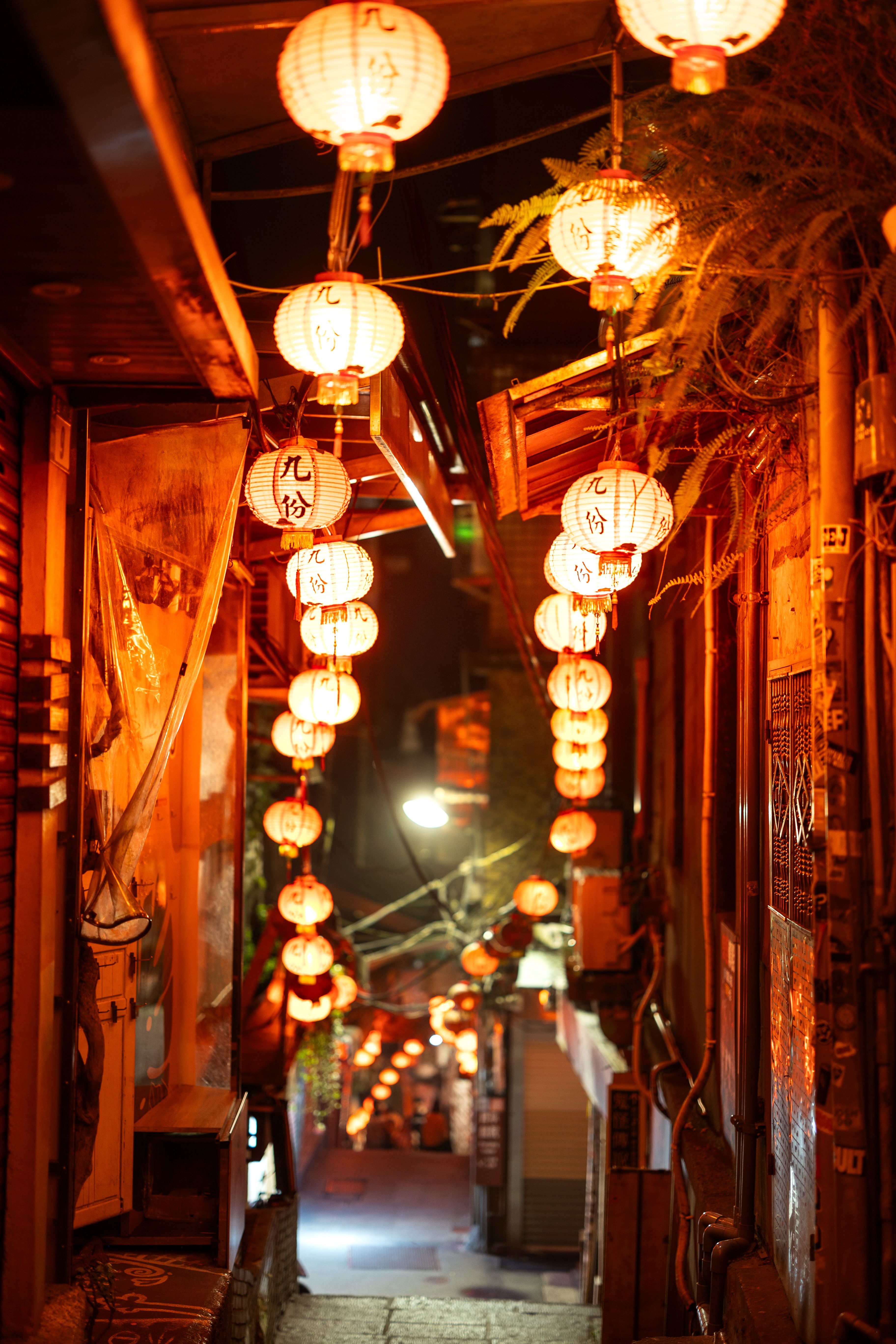A narrow alley with lanterns hanging from the ceiling · Free Stock Photo