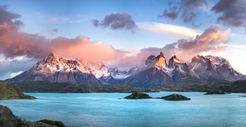 Free Beautiful landscape of Torres del Paine mountains with a vibrant sky at sunset over a calm lake. Stock Photo