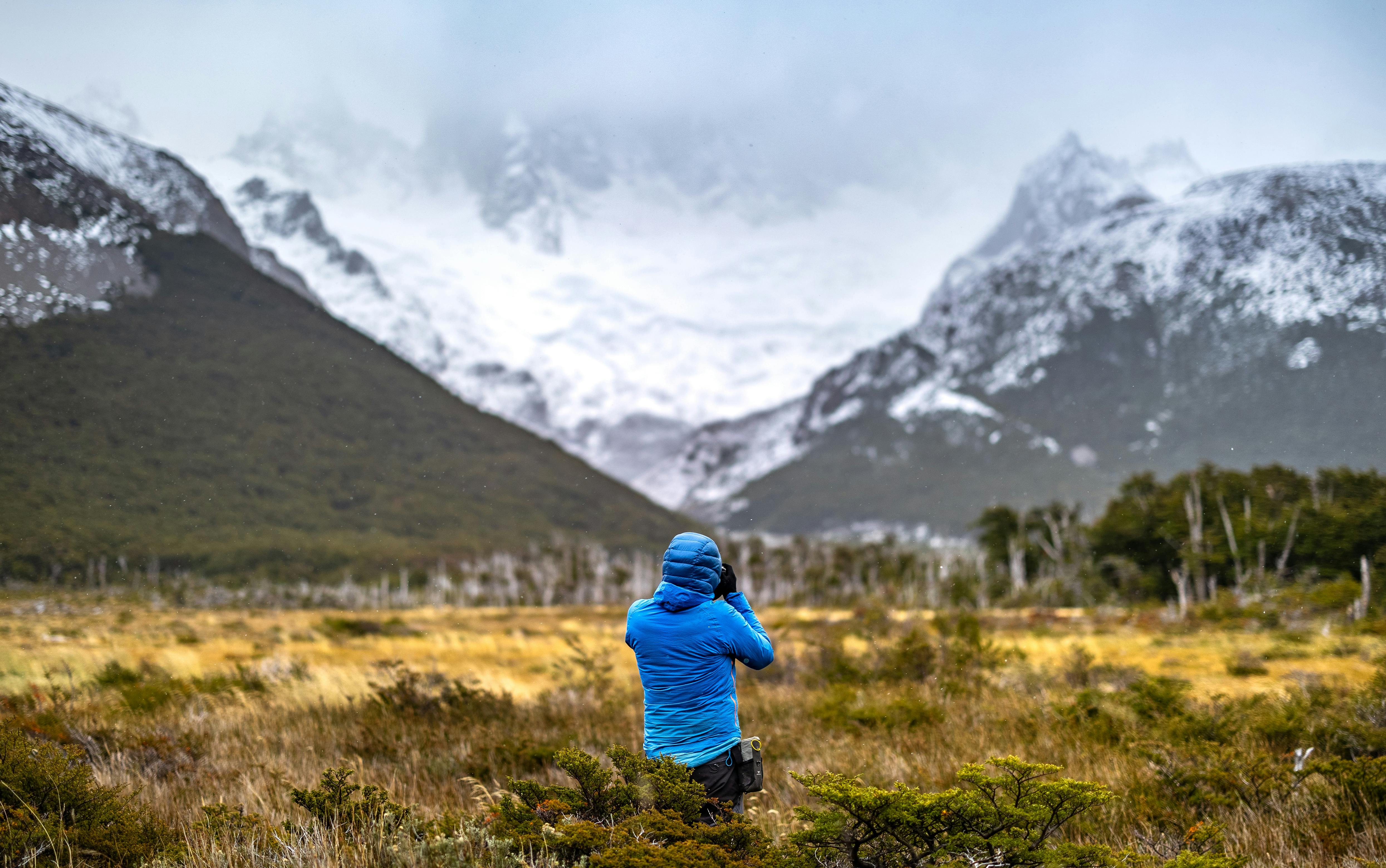 a person taking a picture of a mountain range