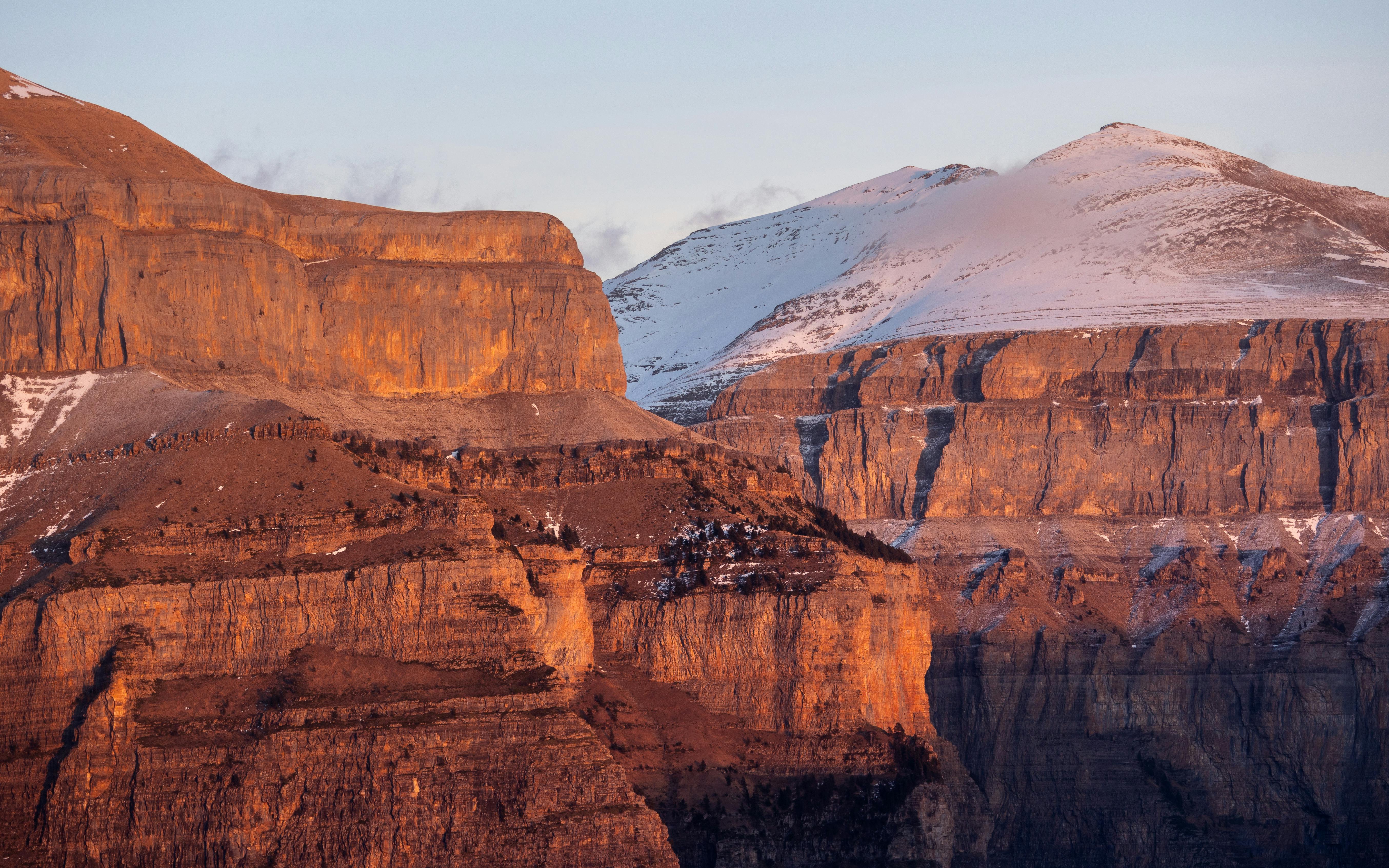 Prescription Goggle Inserts - Stunning sunset view of the Ordesa Valley with snow-capped cliffs and orange rocks in winter.