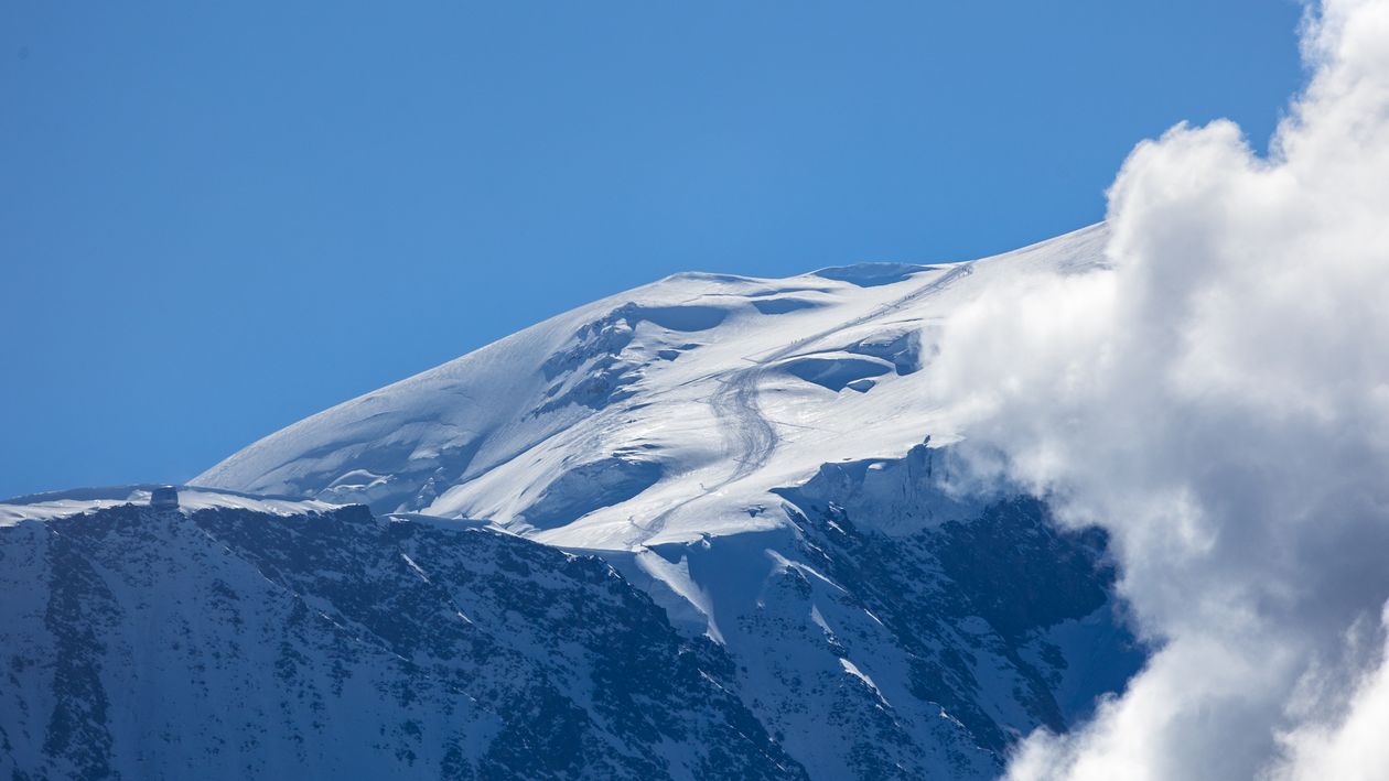 A snow covered mountain with clouds in the sky · Free Stock Photo