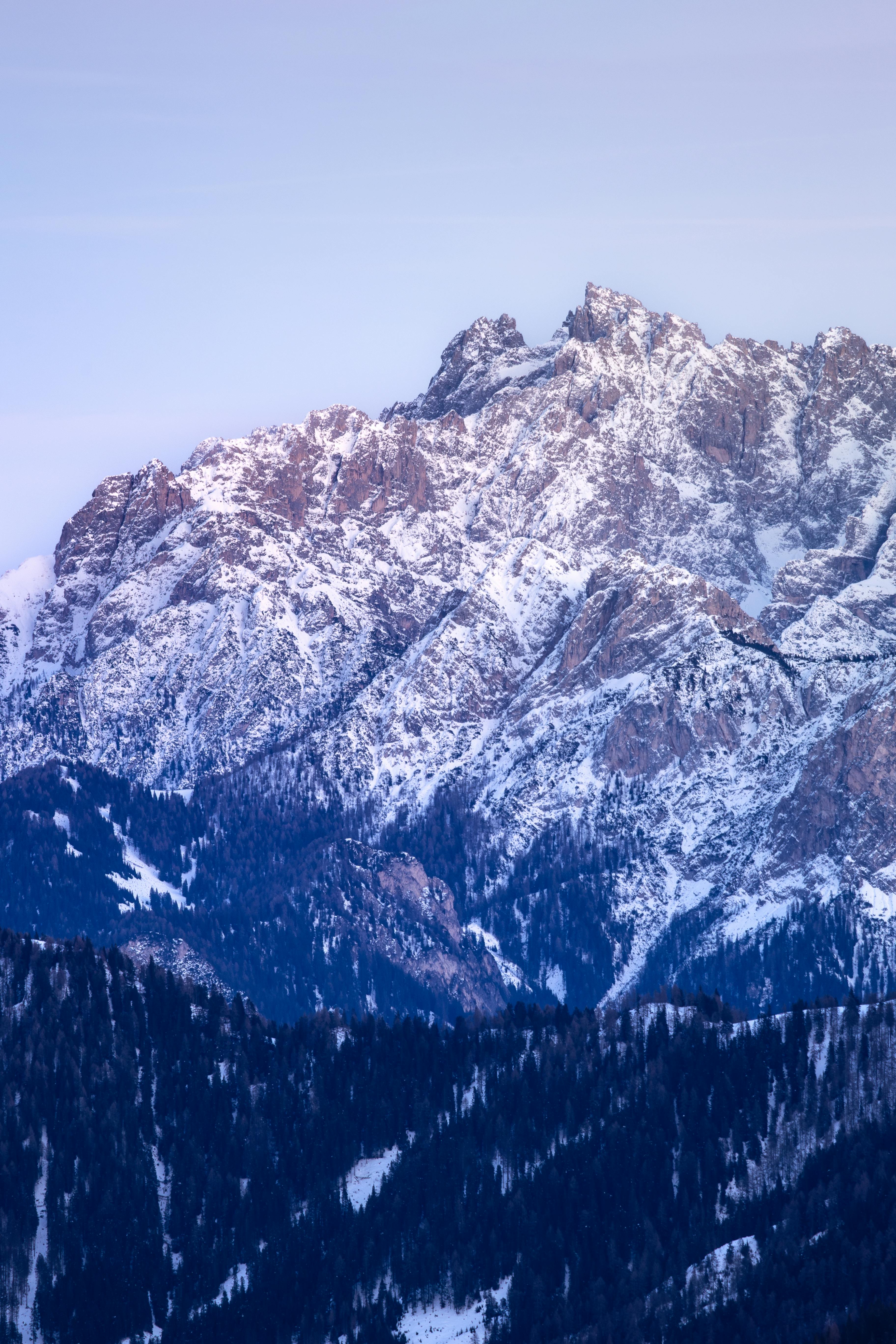 Beautiful snow-covered peaks of the Dolomites under a twilight sky. Scenic winter wonderland.