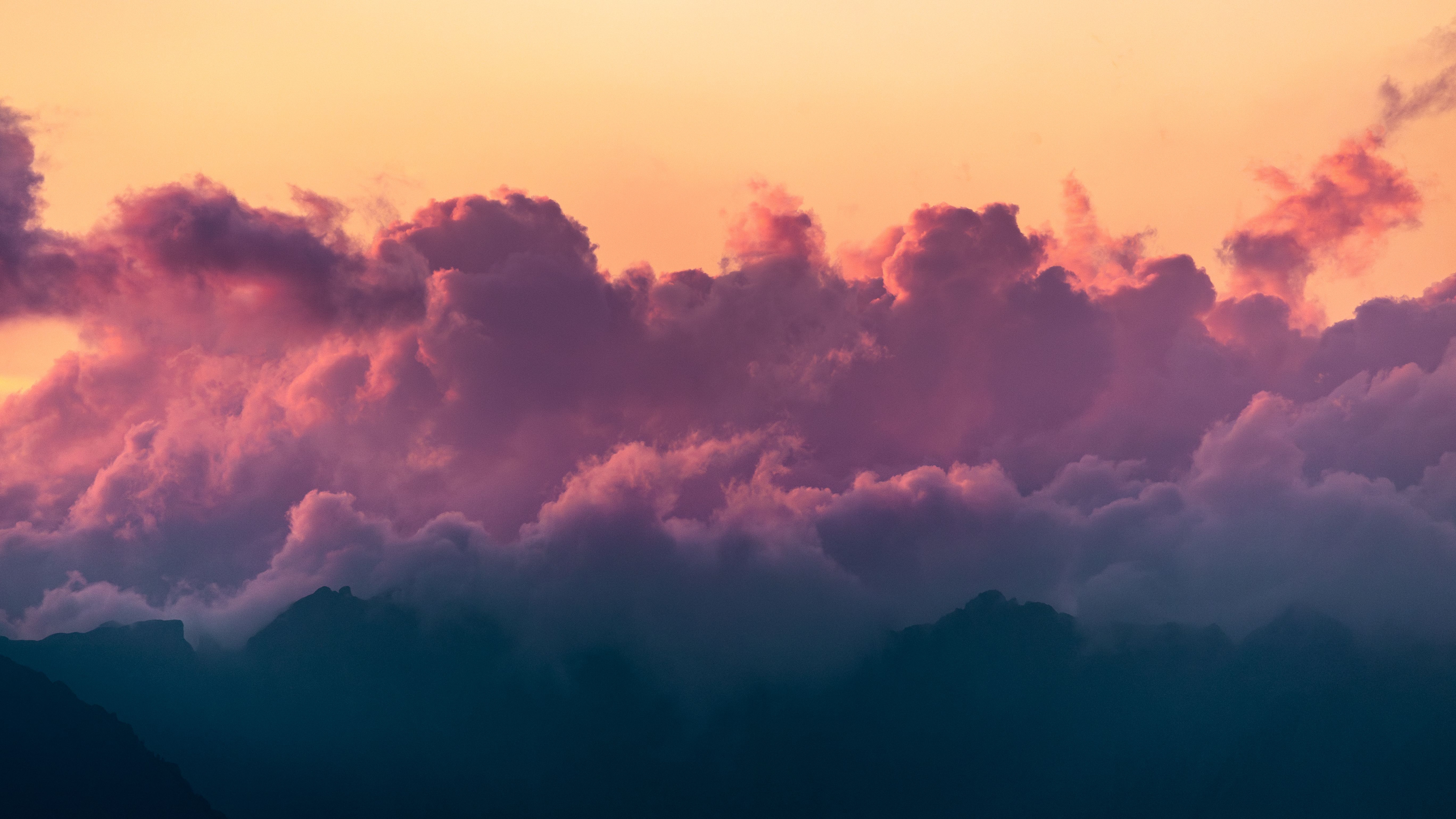 A sunset with clouds and mountains in the background · Free Stock Photo